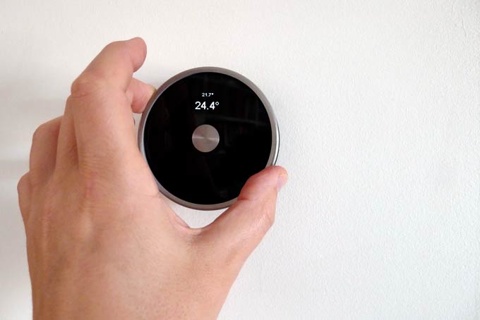 DIY Nest Thermostat with hand adjusting target temperature showing scale of circular housing